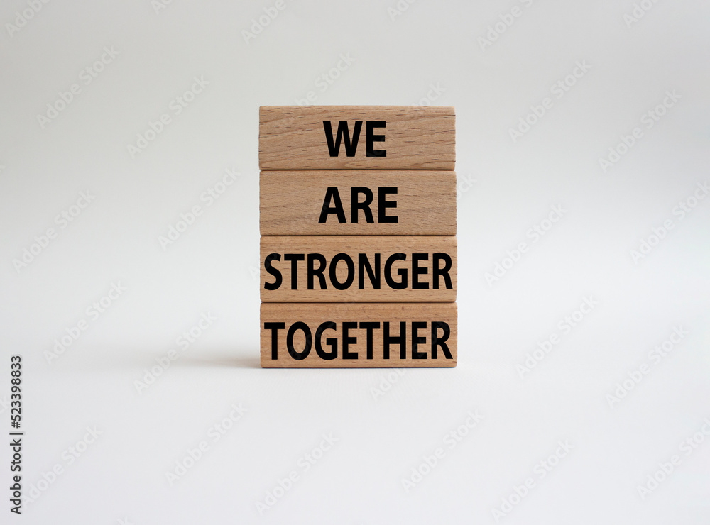 We are stronger together symbol. Wooden blocks with words We are stronger together. Beautiful white background. We are stronger together concept. Copy space.