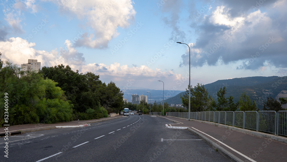 Fototapeta premium A road that crosses a beautiful natural landscape of mountains and hills combined with blue sky and clouds