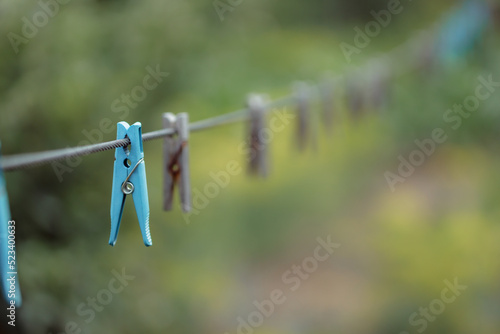Outdoor clothes dryer. Free space for ideas. Blue and wooden clothespins on a clothesline. Selective focus on one clothespin.