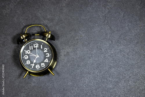 alarm o'clock showing 7 o'clock on gray grunge background photo