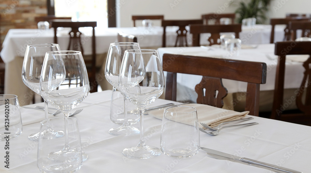 Restaurant table set up with tableware and wine glass. Interior of italian restaurant Restaurant table set up with tableware and wine glass. Interior of italian restaurant
