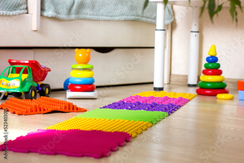 Multicolored orthopedic mats for feet in children's room at home.