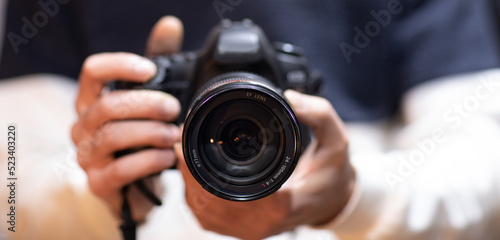 man holds modern digital black camera