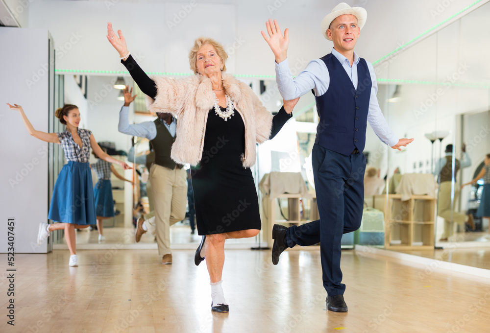 Mature woman dancing swing with young man