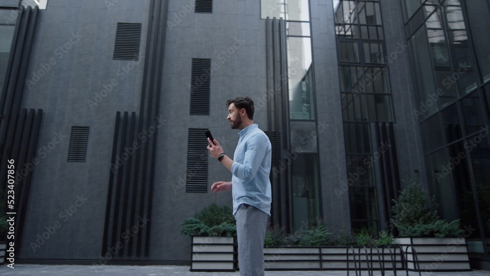 Handsome man standing typing mobile phone at office district. Social networking Handsome man standing typing mobile phone at office district. Social networking