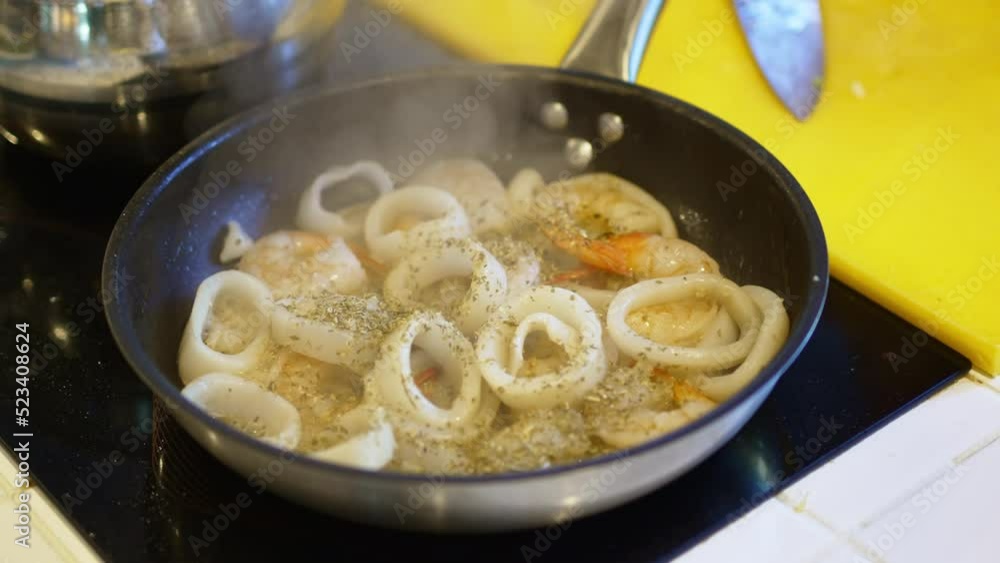 in a hot frying pan fry squid rings and shrimp with spices. in a hot frying pan fry squid rings and shrimp with spices.