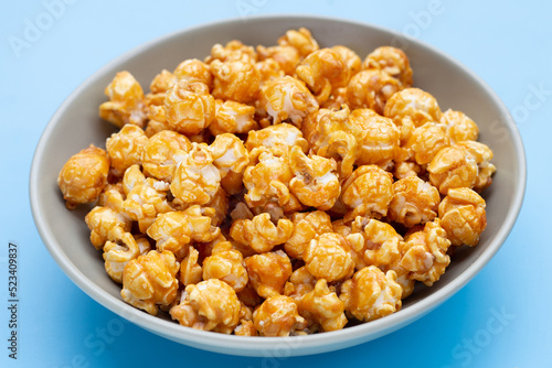Honey caramel popcorn on blue background.