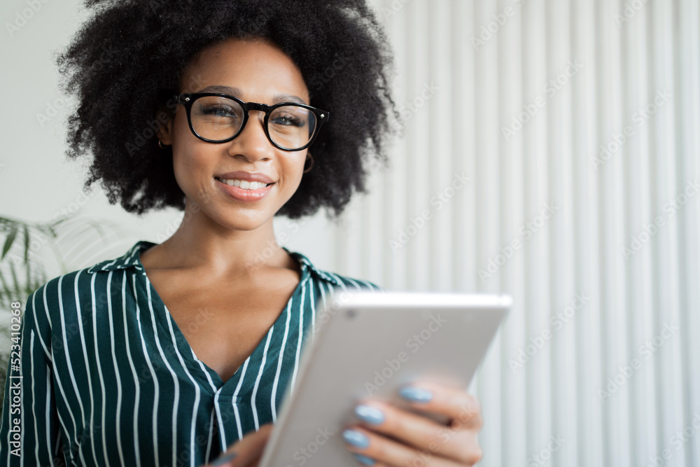 A female manager with glasses in formal clothes works in the office uses a tablet A female manager with glasses in formal clothes works in the office uses a tablet