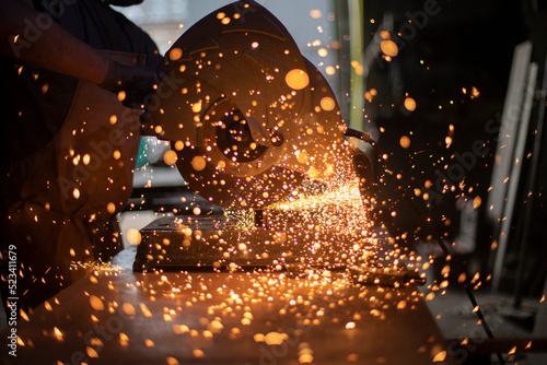Sparks from grinder. Metal cutting. Bright lights in dark. Industrial background. © Олег Копьёв