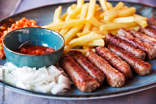 Obraz na płótnie Traditional Cevapcici, ground meat rolls with french fries. Porec, Croatia. w salonie