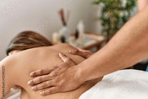Woman reciving back massage at beauty center.