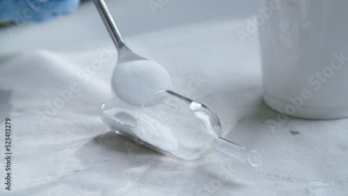 White poweder into scoop for scientific experiment. Close up.