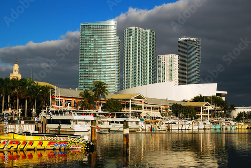 Clouds begin to wane, creating sunny skies over the boats of The Bayside Marina in Miami photo
