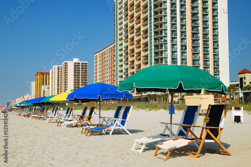 Umbrellas and folding chairs are set up along the sand on the Grand Strand of Myrtle Beach, South Carolina, waiting for the next summer vacation person to enjoy relaxation