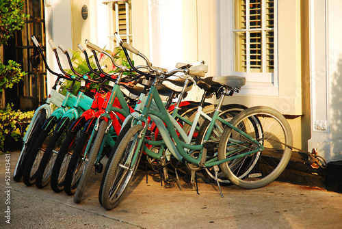 Bikes at a rental store are lined and locked on the rack in Charleston