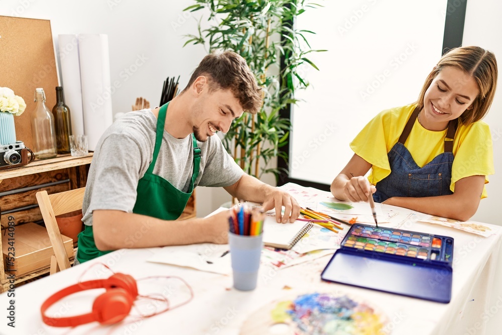 Young hispanic artist couple smiling happy drawing at art studio. Young hispanic artist couple smiling happy drawing at art studio.