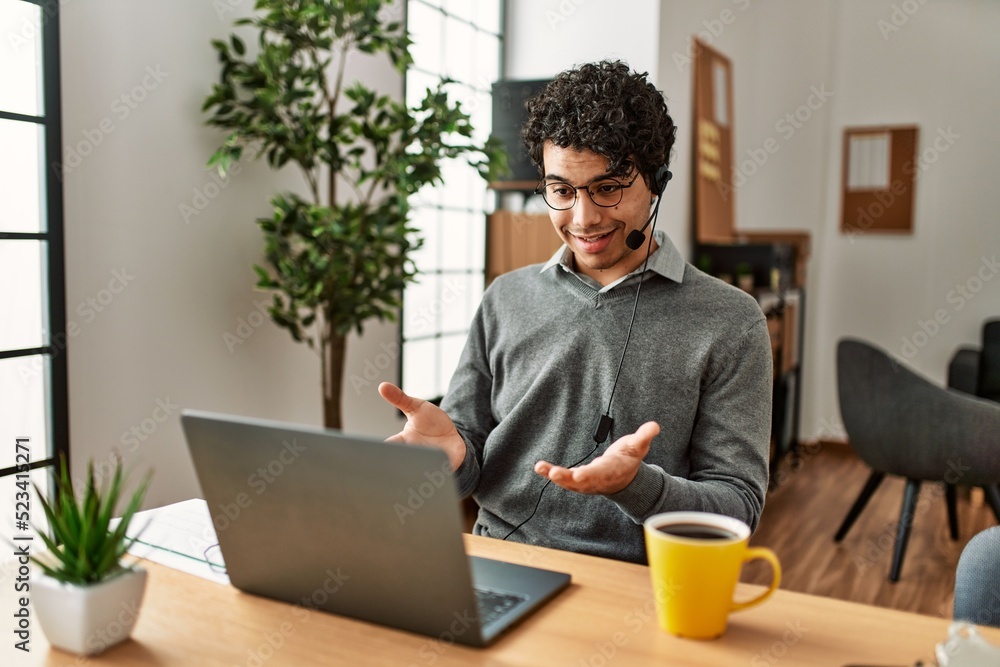 Young hispanic call center agent man having video call at the office. Young hispanic call center agent man having video call at the office.