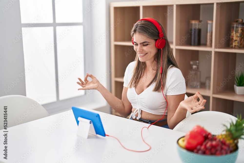 Young woman doing yoga exercise sitting on table at home Young woman doing yoga exercise sitting on table at home