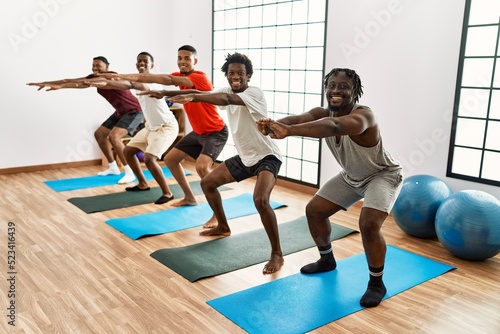 Group of young african american man training yoga at sport center.