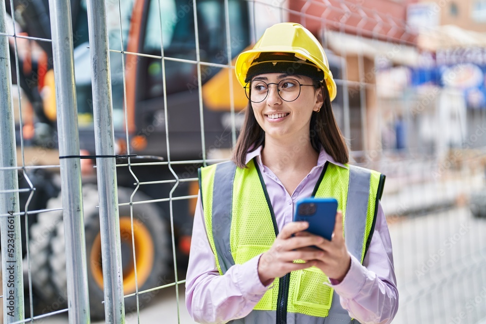 Young hispanic woman architect using smartphone at street Young hispanic woman architect using smartphone at street