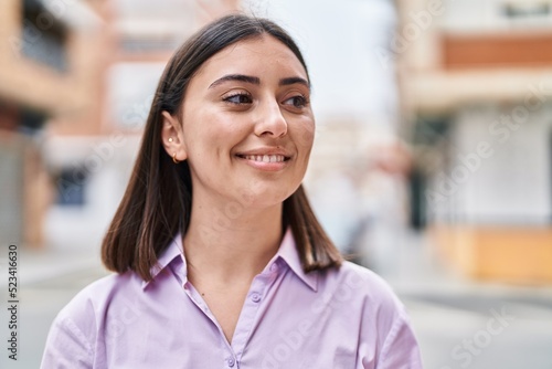 Young hispanic woman smiling confident standing at street