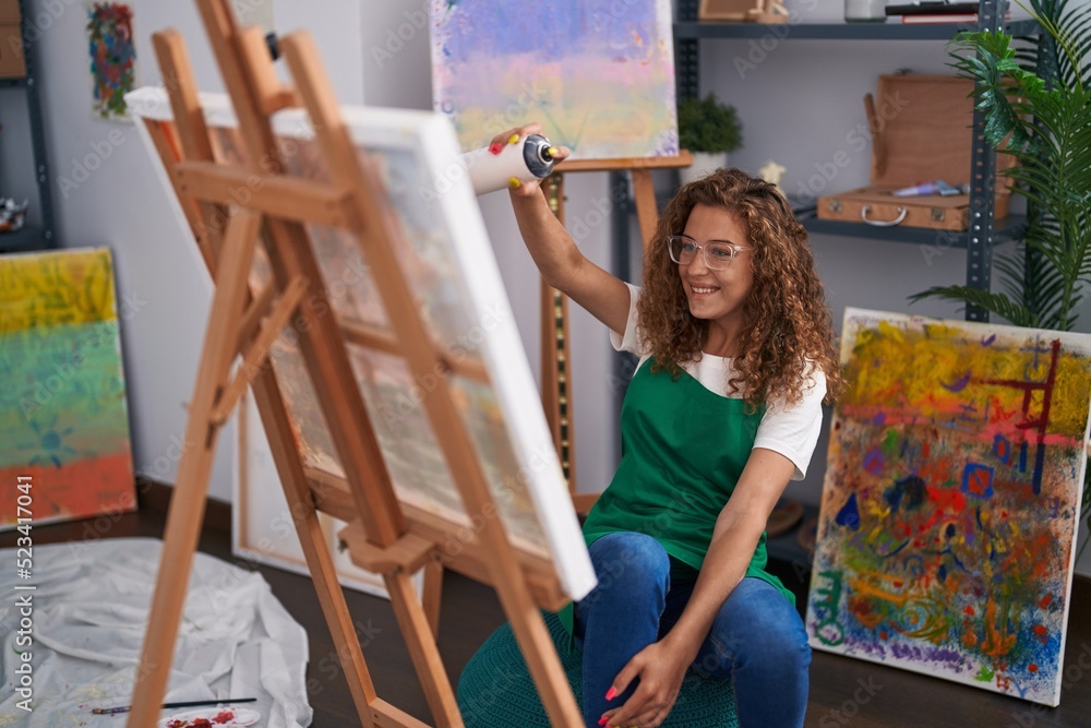 Young beautiful hispanic woman artist smiling confident using graffiti spray drawing at art studio Young beautiful hispanic woman artist smiling confident using graffiti spray drawing at art studio
