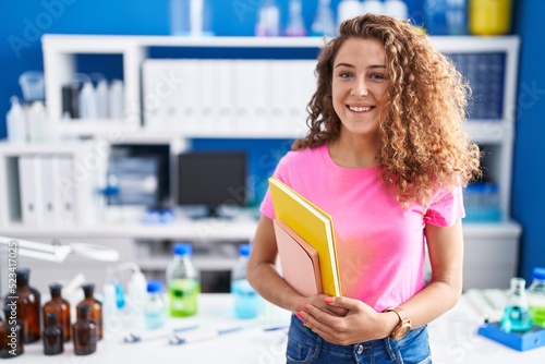 Young caucasian student woman at scientist laboratory looking positive and happy standing and smiling with a confident smile showing teeth