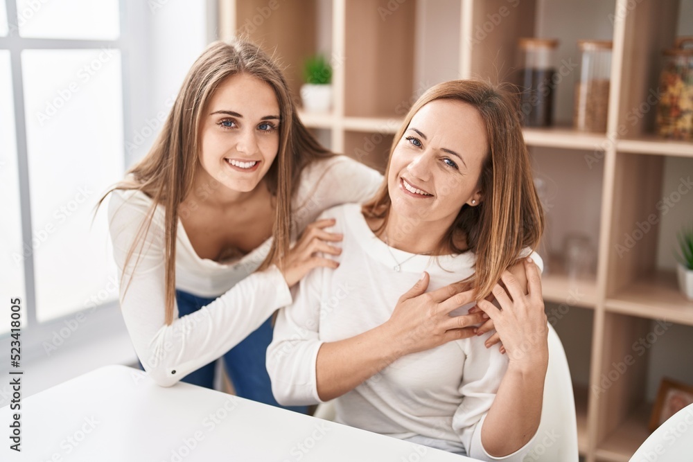 Two women mother and daughter hugging each other at home Two women mother and daughter hugging each other at home