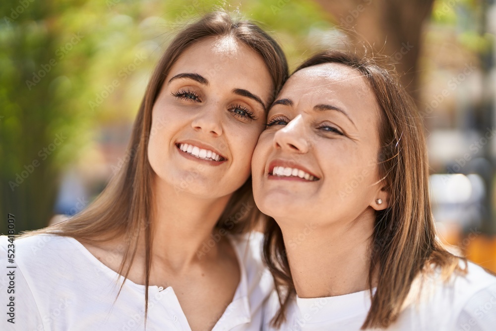 Two women mother and daughter standing together at park Two women mother and daughter standing together at park