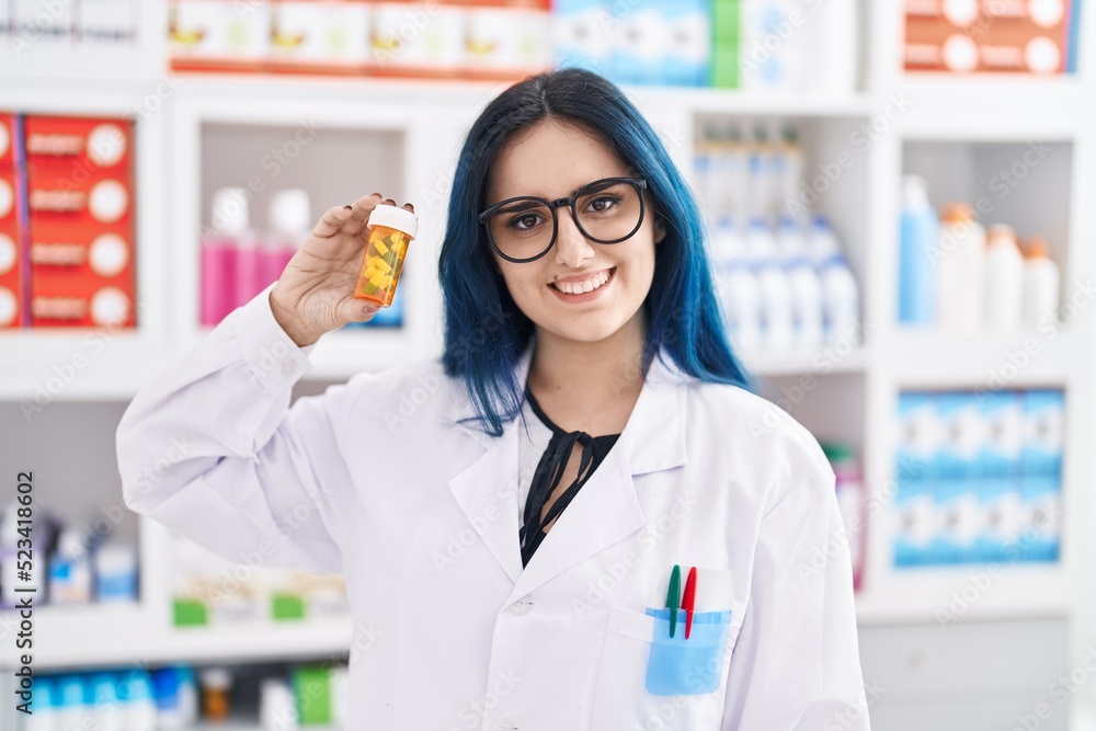 Young caucasian woman pharmacist smiling confident holding pills bottle at pharmacy Young caucasian woman pharmacist smiling confident holding pills bottle at pharmacy