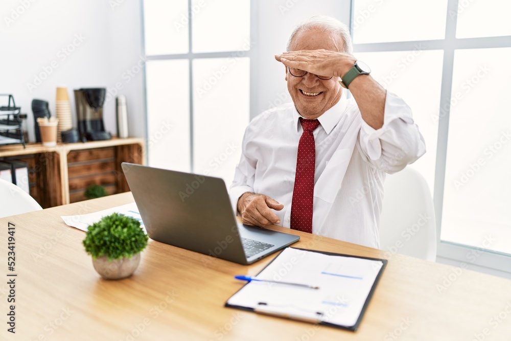 Senior man working at the office using computer laptop covering eyes with hand, looking serious and sad. sightless, hiding and rejection concept Senior man working at the office using computer laptop covering eyes with hand, looking serious and sad. sightless, hiding and rejection concept