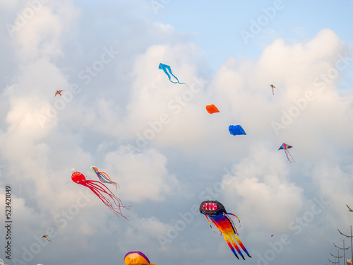 A kite in the sky. Upwards. Wind. Kite Festival. Colorful toys. People fly kites.   Holiday at the resort