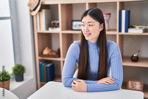 Chinese woman smiling confident sitting on sofa at home