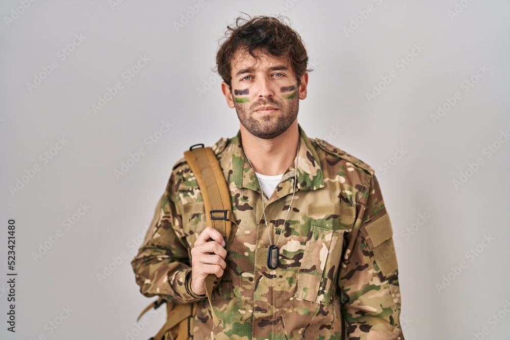 Hispanic young man wearing camouflage army uniform skeptic and nervous, frowning upset because of problem. negative person.