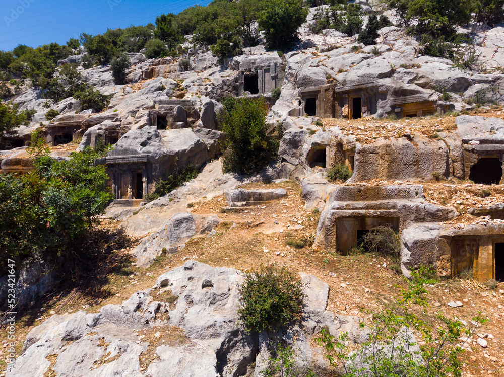 Impressive view of historical remains of Lycian rock tombs on slope of Mount Tocak in ancient city of Limyra in Turkey..