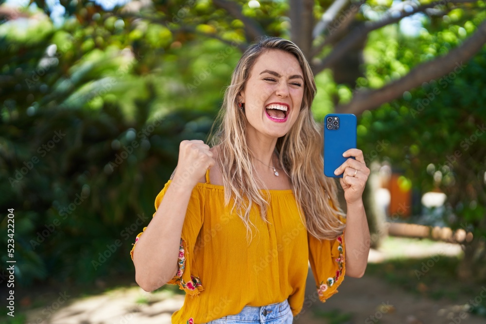 Young woman using smartphone with cheerful expression at park Young woman using smartphone with cheerful expression at park