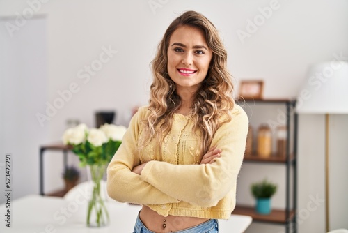 Young woman smiling confident standing with arms crossed gesture at home © Krakenimages.com