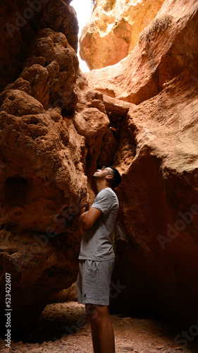 Hombre en un estrecho de rocas rojizas similar al gran cañón del colorado