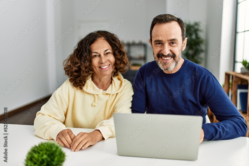 Middle age hispanic couple smiling happy using laptop at home. Middle age hispanic couple smiling happy using laptop at home.