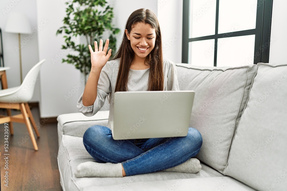 Young latin woman having video call sitting on sofa at home Young latin woman having video call sitting on sofa at home