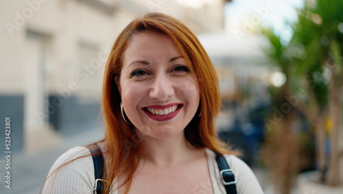 Young redhead woman smiling confident standing at street