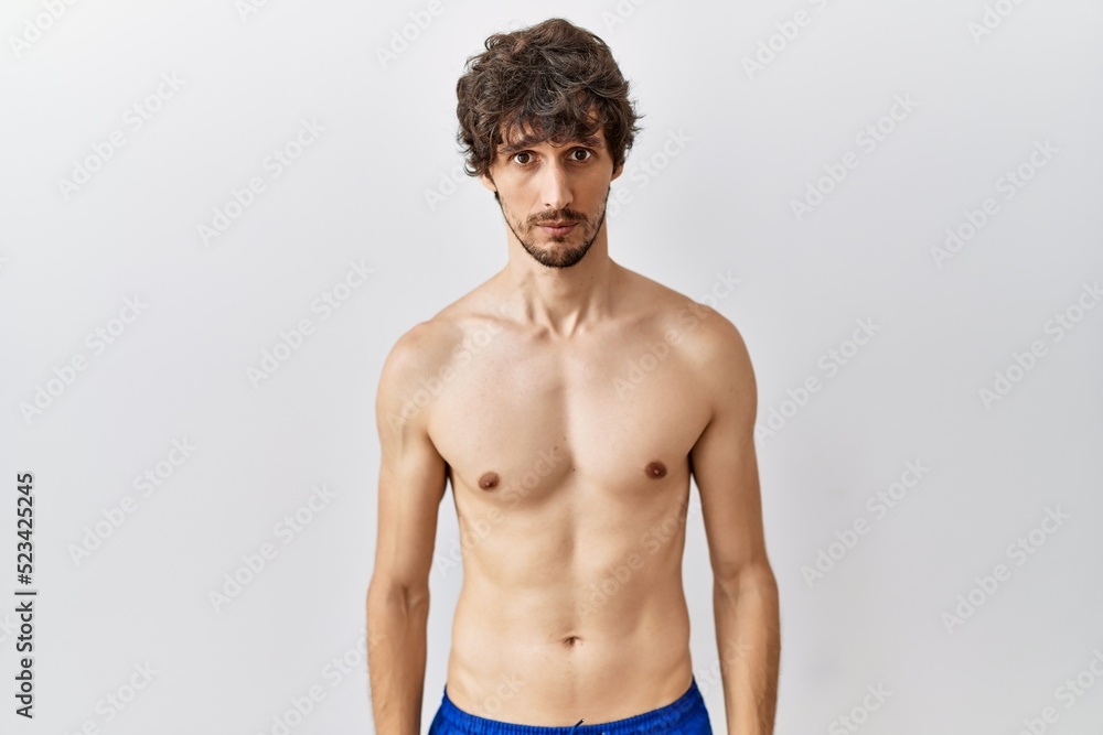 Fototapeta premium Young hispanic man standing shirtless over isolated, background depressed and worry for distress, crying angry and afraid. sad expression.