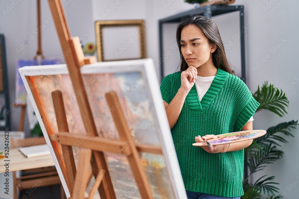 Young hispanic woman artist drawing with doubt expression at art studio Young hispanic woman artist drawing with doubt expression at art studio