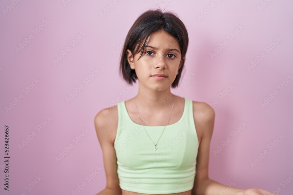 Young girl standing over pink background clueless and confused with open arms, no idea concept. Young girl standing over pink background clueless and confused with open arms, no idea concept.