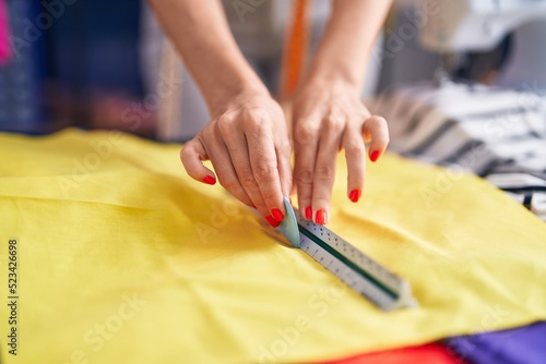 Young blonde woman tailor working at sewing studio
