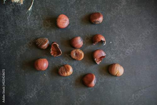 Chestnuts on dark grey background. Pile of fresh chestnuts ready to roast. Top view, copy space. Flat lay. Space for text