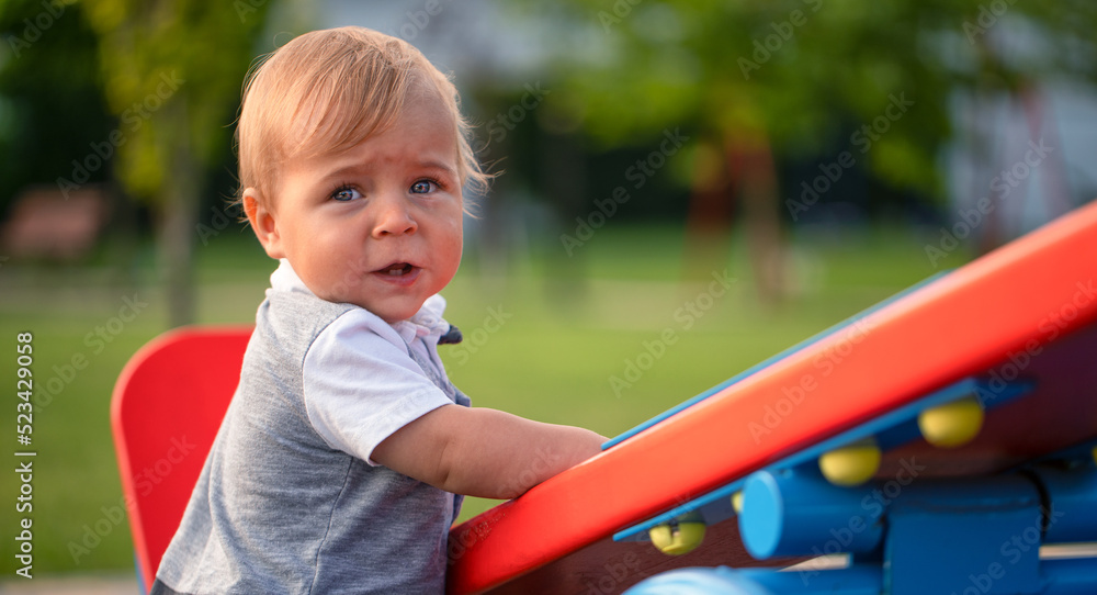 A little boy is swinging on a swing on a beautiful summer day. A little boy is swinging on a swing on a beautiful summer day.