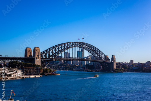 朝のオーストラリア・シドニーで、オペラハウス近くから見たハーバーブリッジ周辺の風景と青空 © 和紀 神谷