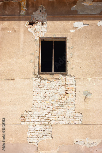 Wood framed window is open with or without glass on a worn brick and plaster  historic building in Osijek, Croatia.