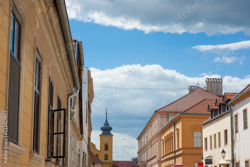 Osijek Street scene near Citadel in Croatia with St Michael Church in background with blue skies and clouds above.
